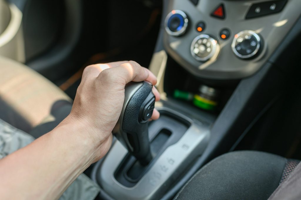 Driver male hand holding automatic gear shift